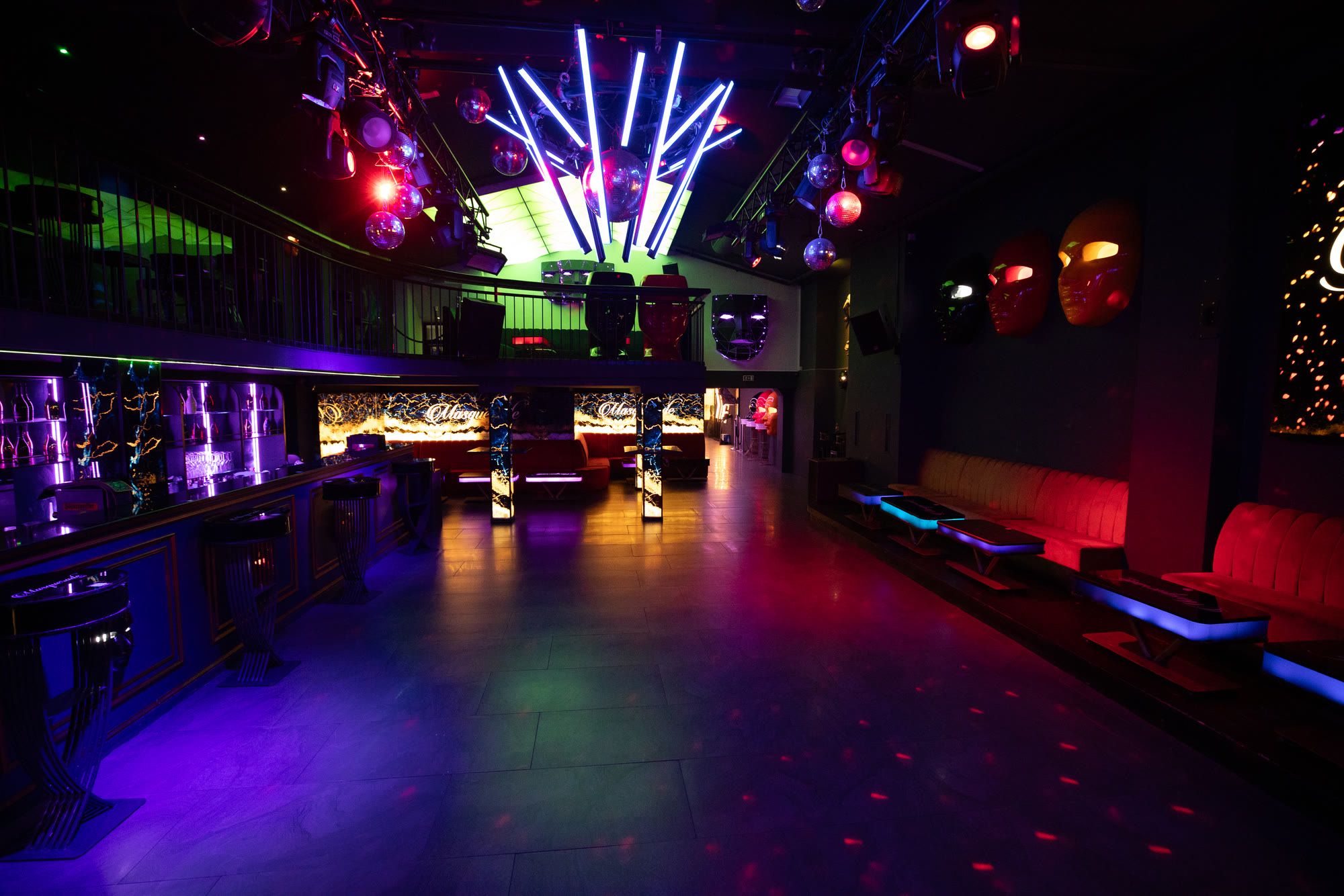 Tanzfläche im Masquerade-Hauptraum mit Lichtstäben, Bar und Sitznischen